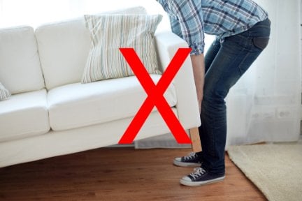 Photo of a person moving furniture, with a cross through it